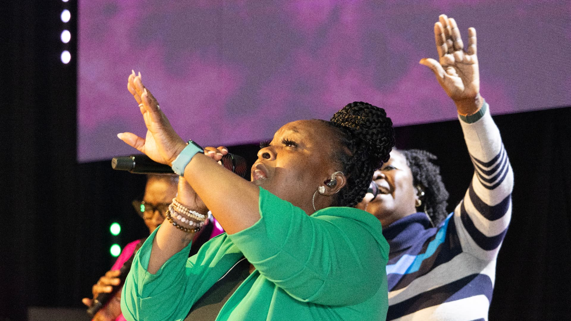 Worship leader singing with hand lifted